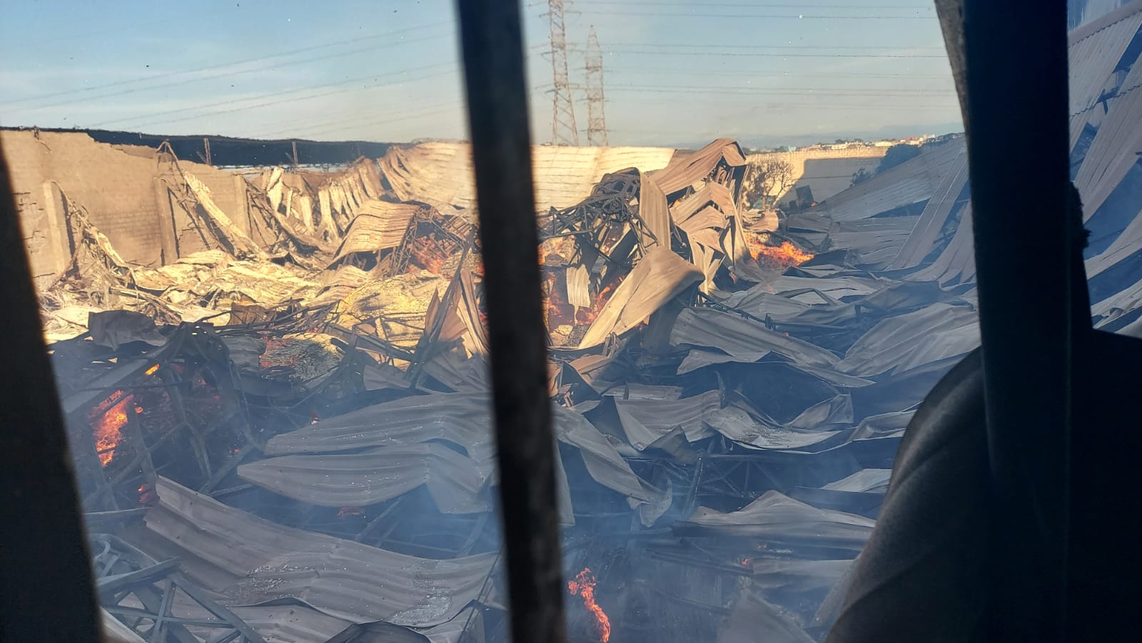 Galpão desaba e incêndio em depósito de madeira interdita BR-101 na Serra