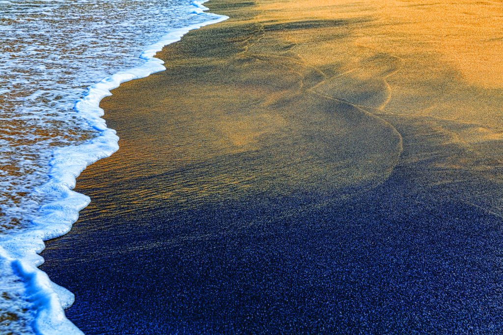 A praia tem areias de cor escura devido à concentração natural de metais pesados. Segundo estudos, a areia tem propriedades terapêuticas. Foto: Marcelo Moryan/MTur