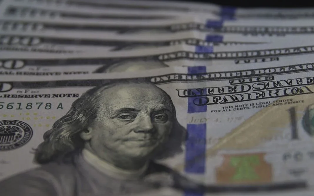 Dólar encerra o dia em alta cautelosa devido a conflitos e decisões do Fed.
