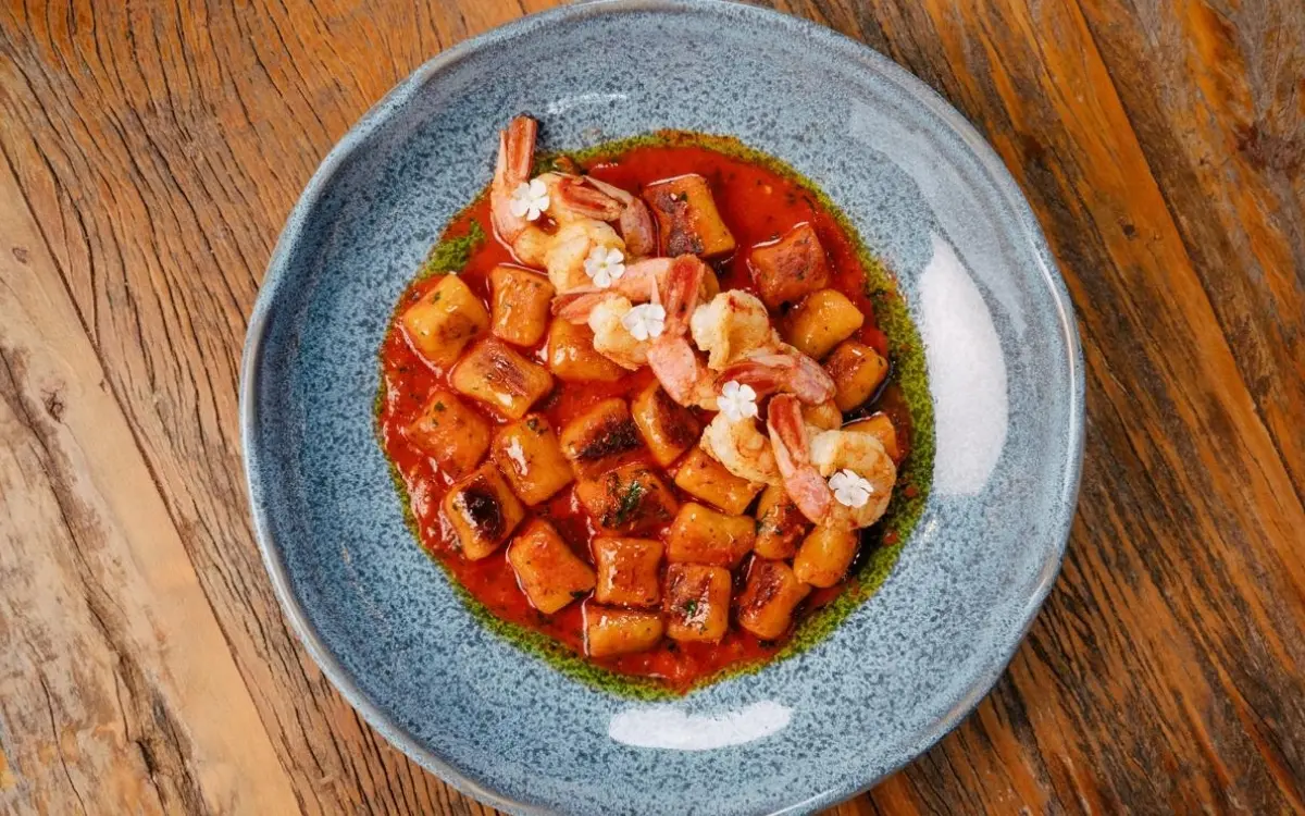 Prato de gnocchi de banana-da-terra com caldo de moqueca e camarão VG em Pedra Azul.